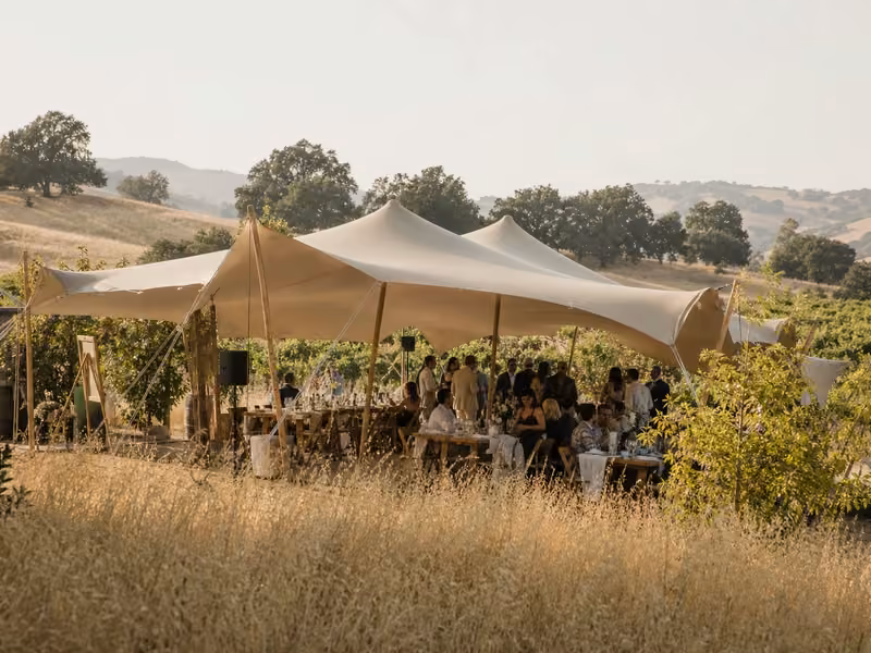 Stretch tent over an intimate wedding reception at dusk