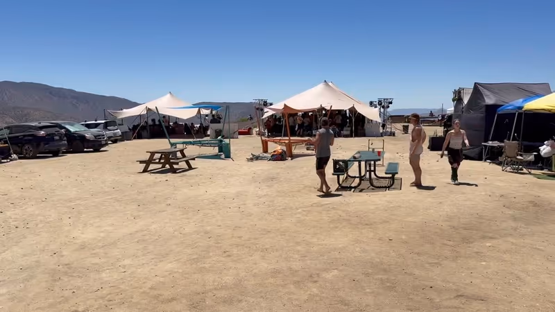 Several stretch tents forming music and lounge zones at a desert festival