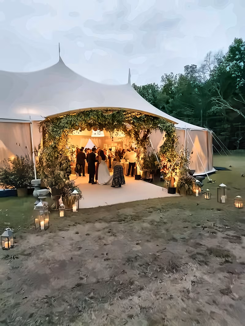 Tent entrance wrapped in greenery glowing at night