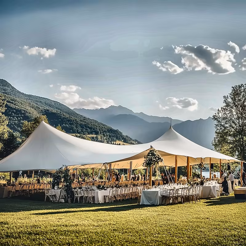 Wedding banquet tables under a tent with mountain views
