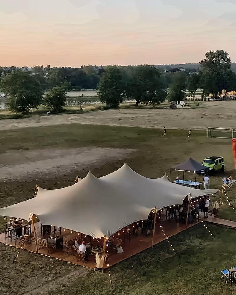 Stretch tent glowing at sunset in an open field