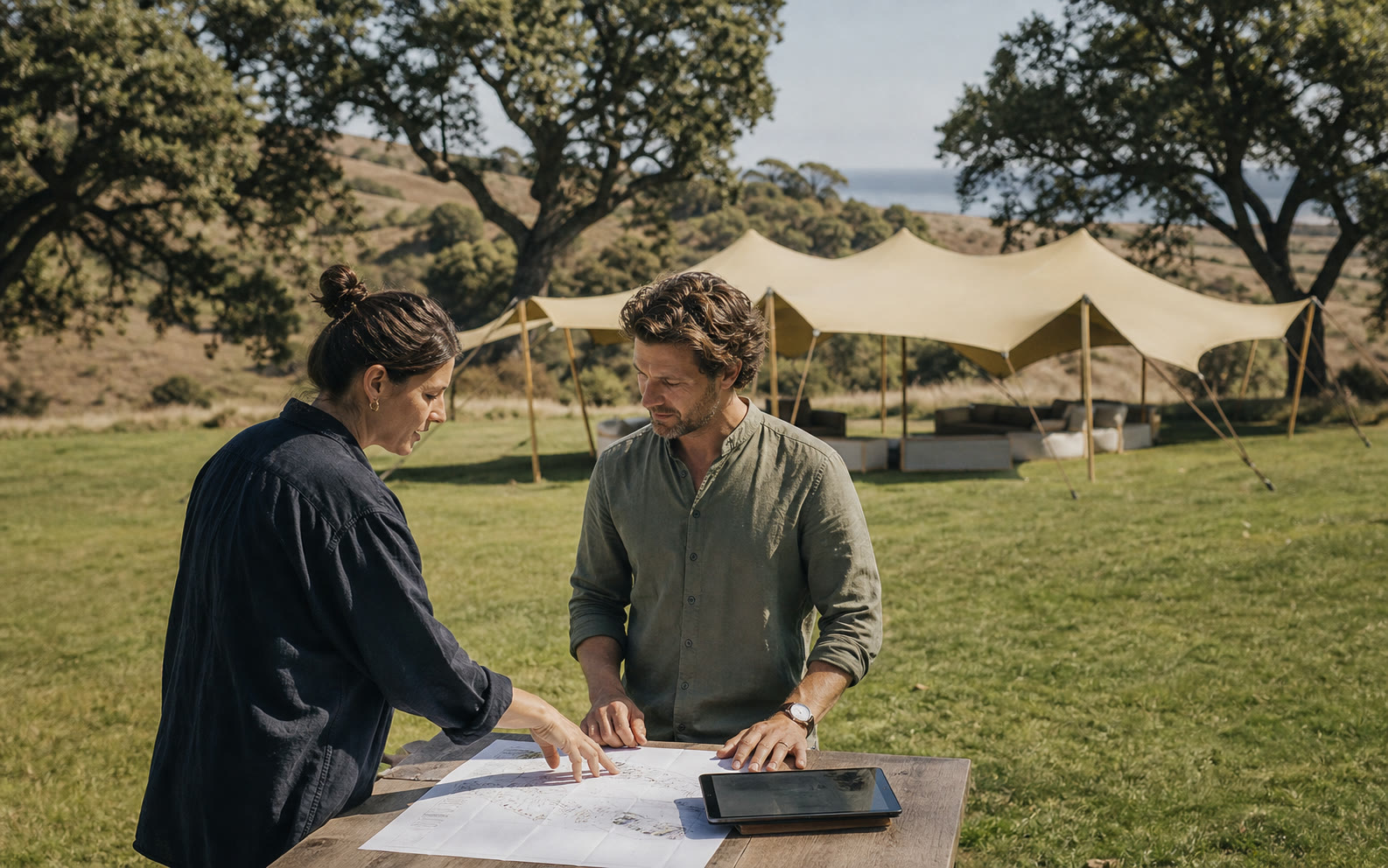 Event planner and client reviewing a stretch tent site plan at a California venue