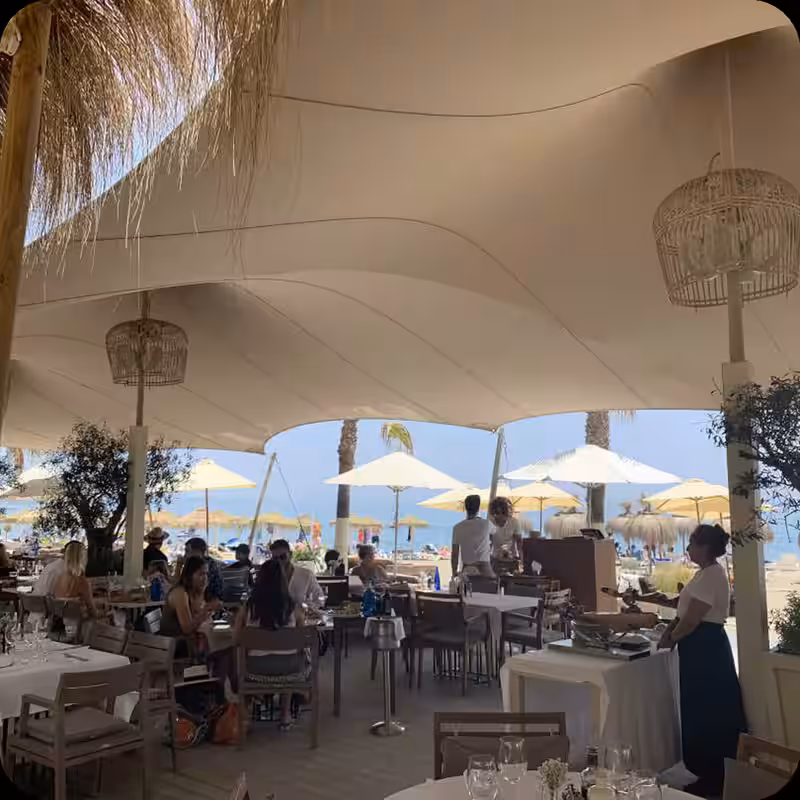 Stretch tent covering a restaurant terrace with string lighting