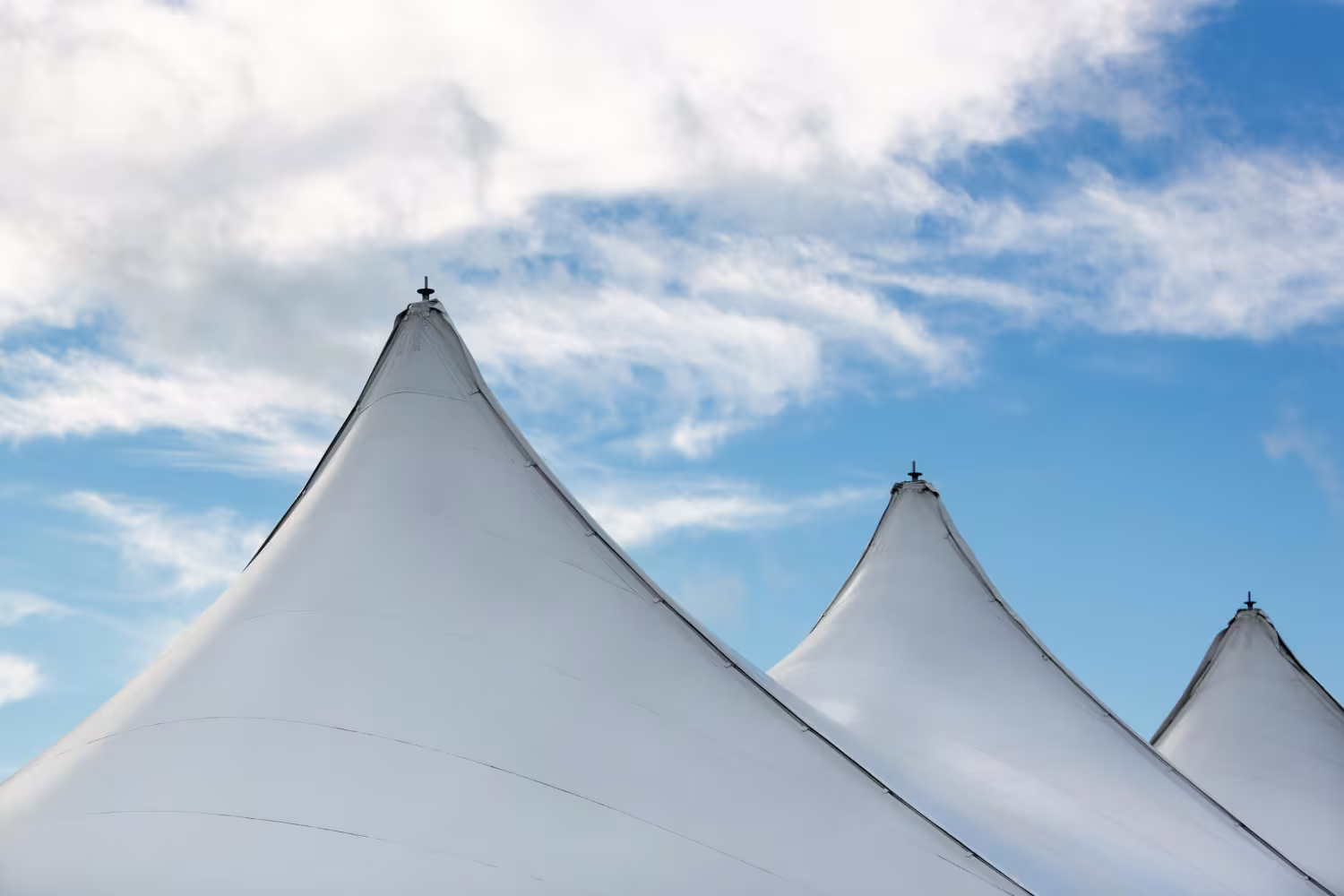 Tensioning the stretch tent fabric gradually and evenly