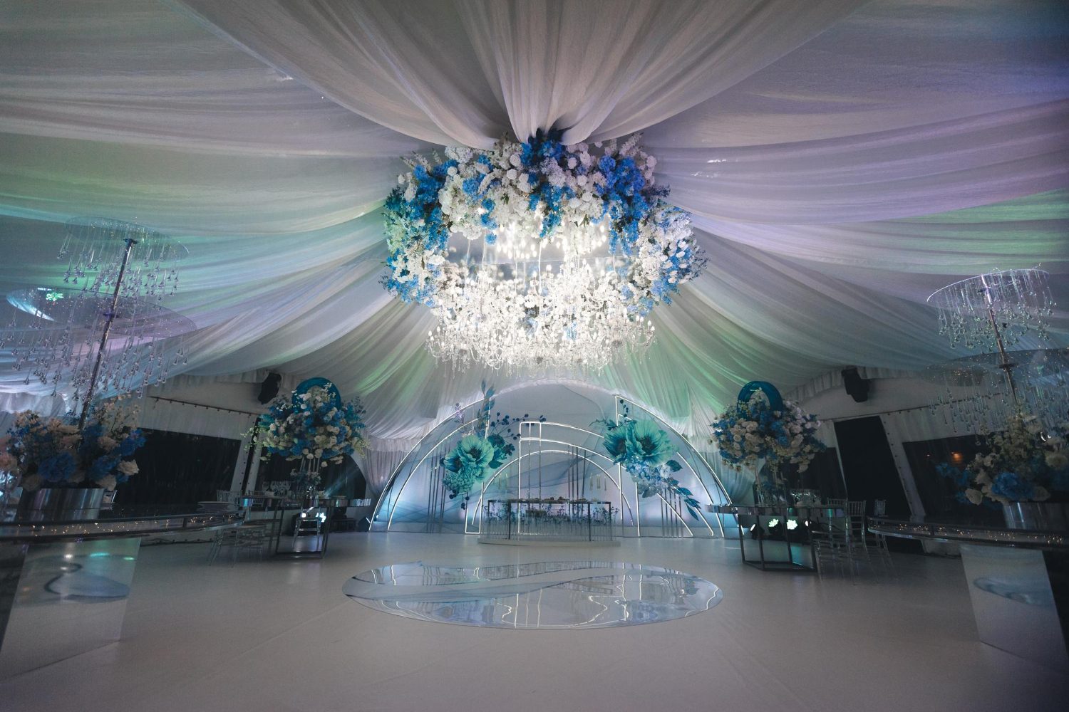 Fabric draping and floral installations under a stretch tent